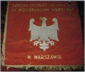 Awers sztandaru. Na nim znajduje się biały orzeł na czerwonym tle, wokół niego widnieje napis "Szkoła Ogólnokształcąca im «Powstańców Warszawy» "w warszawie"